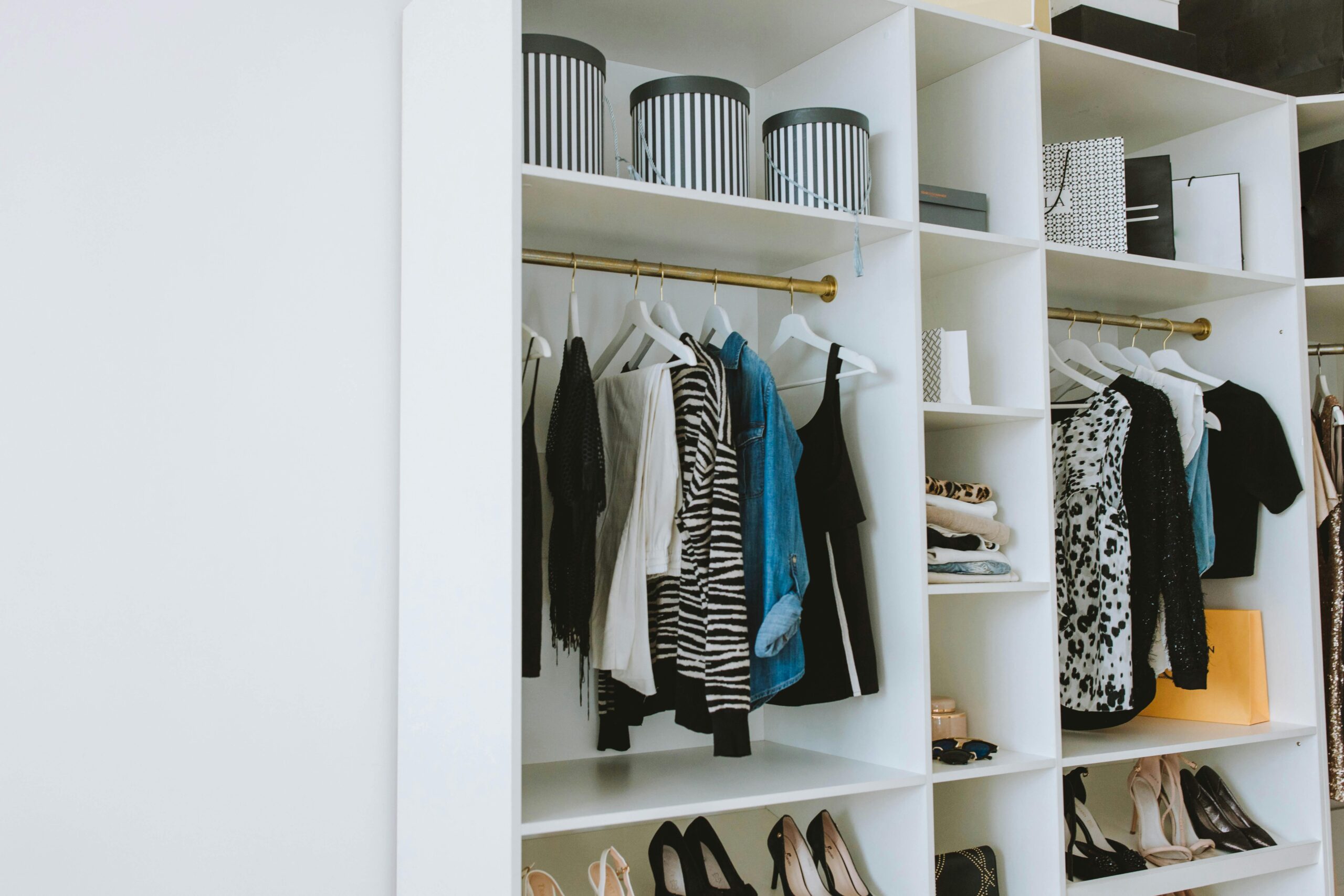 Modern wardrobe shelving with stylish clothes, shoes, and designer accessories.